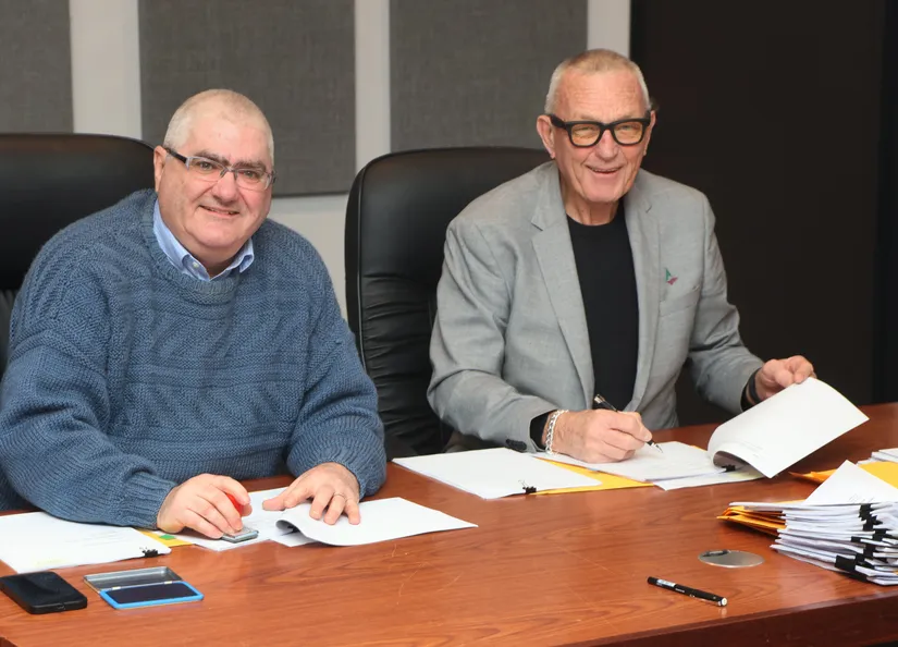 Counci's CEO Martin McCarthy and Mayor Bim Lange signing the first wave of Social Infrastructure Deed documents, seated behind a desk.