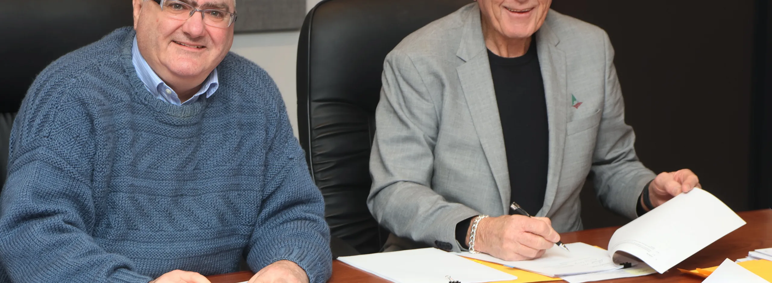Counci's CEO Martin McCarthy and Mayor Bim Lange signing the first wave of Social Infrastructure Deed documents, seated behind a desk.