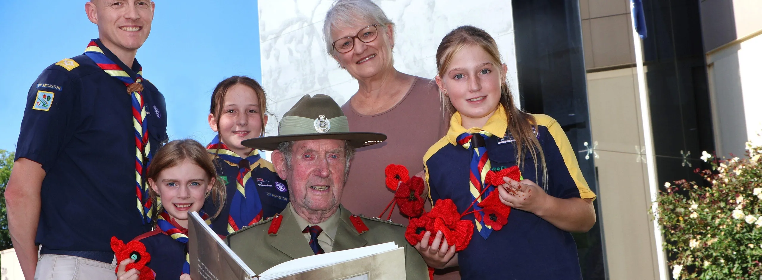 Four scouts, an RSL member wearing medals and uniform, and an historian standing in front of the Nuriootpa Council building.