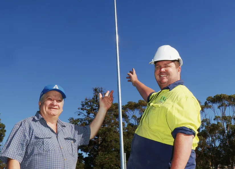 Anthony Schubert and Craig Johnson in front of a new light installed at Angas Recreation Park's main oval