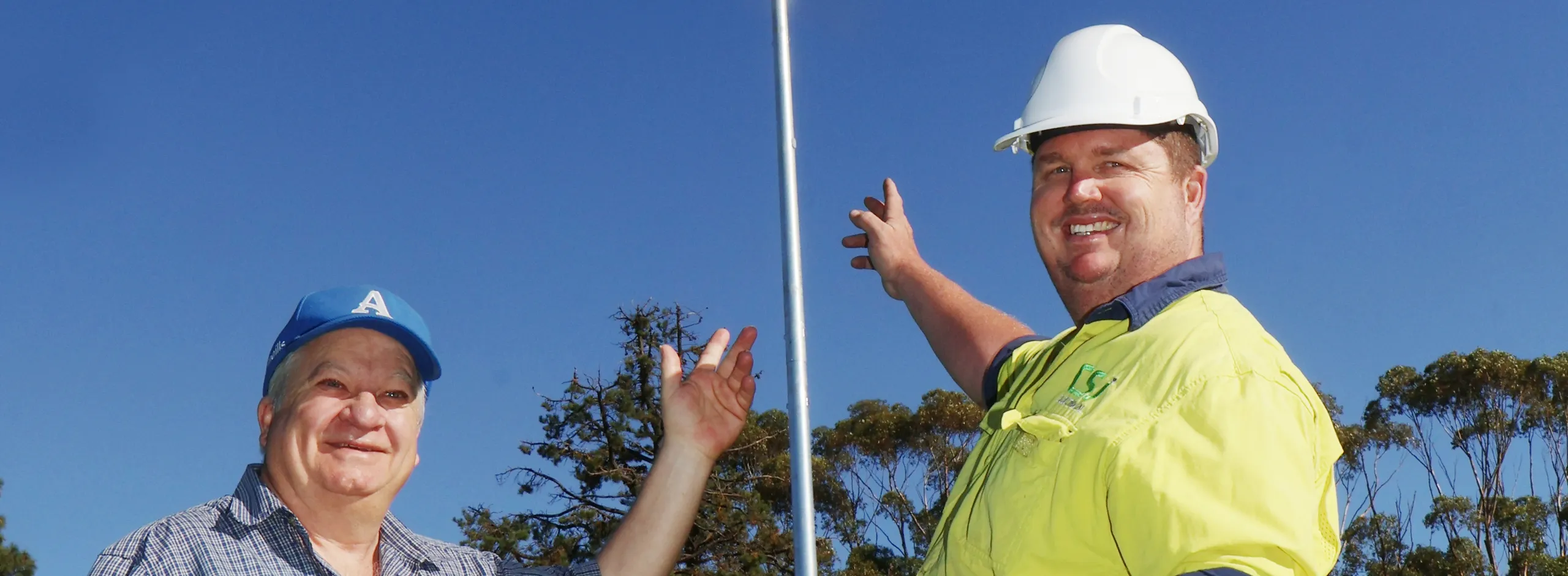 Anthony Schubert and Craig Johnson in front of a new light installed at Angas Recreation Park's main oval