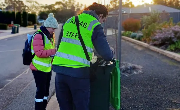 KESAB employs lifting the lid on a green bin located beside a road ready for pick up