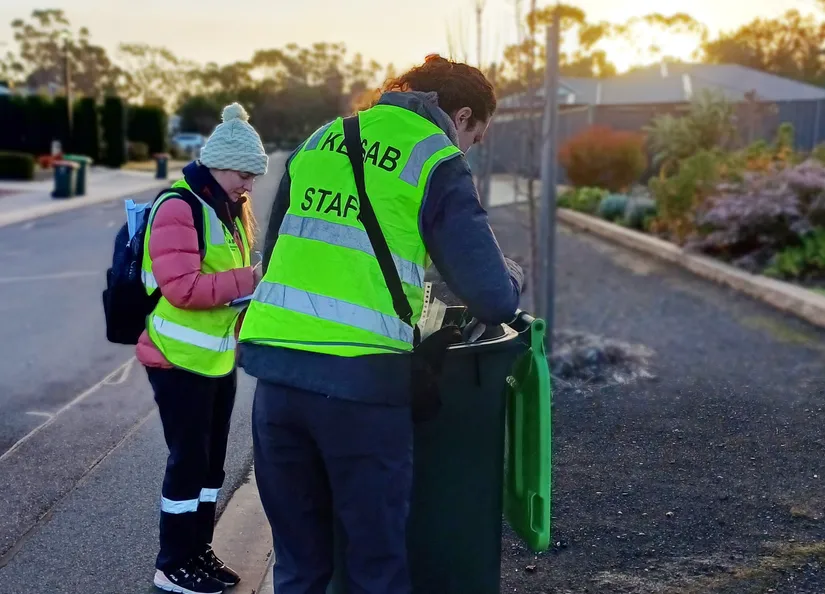 KESAB employs lifting the lid on a green bin located beside a road ready for pick up