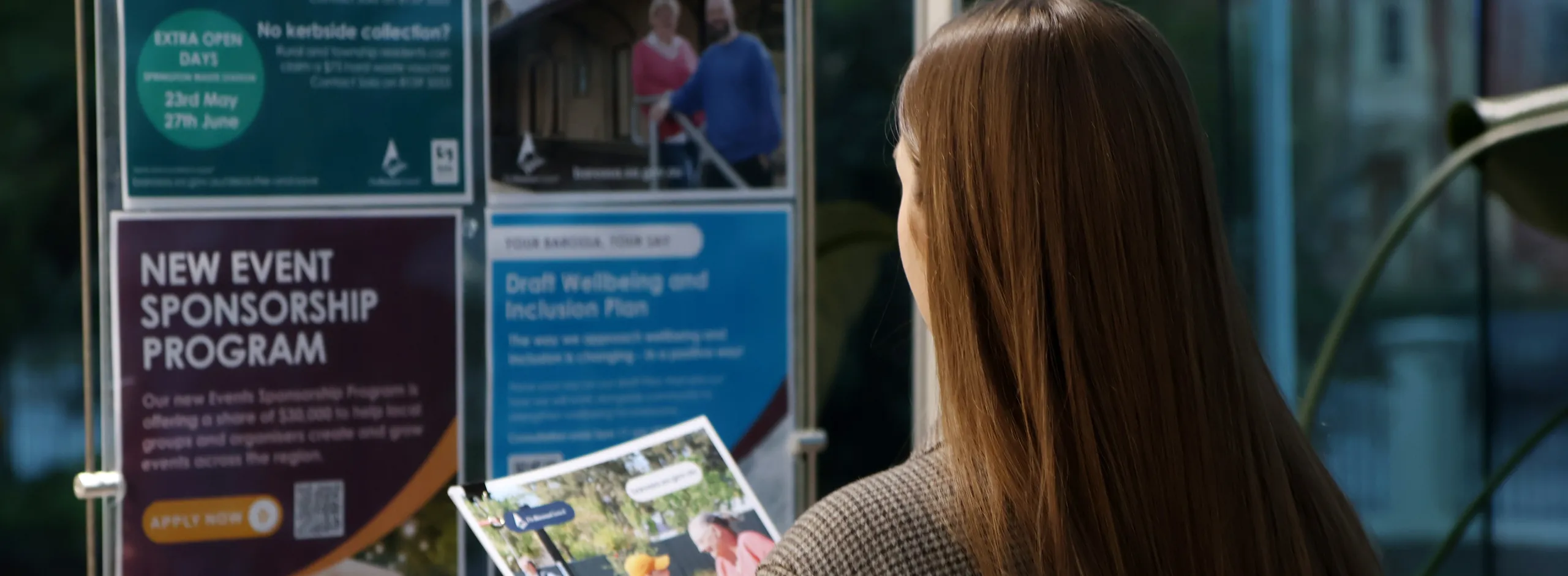 A person holding a book in front of posters
