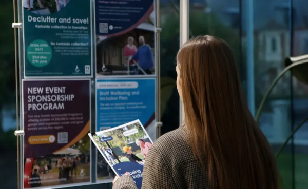 A person holding a book in front of posters