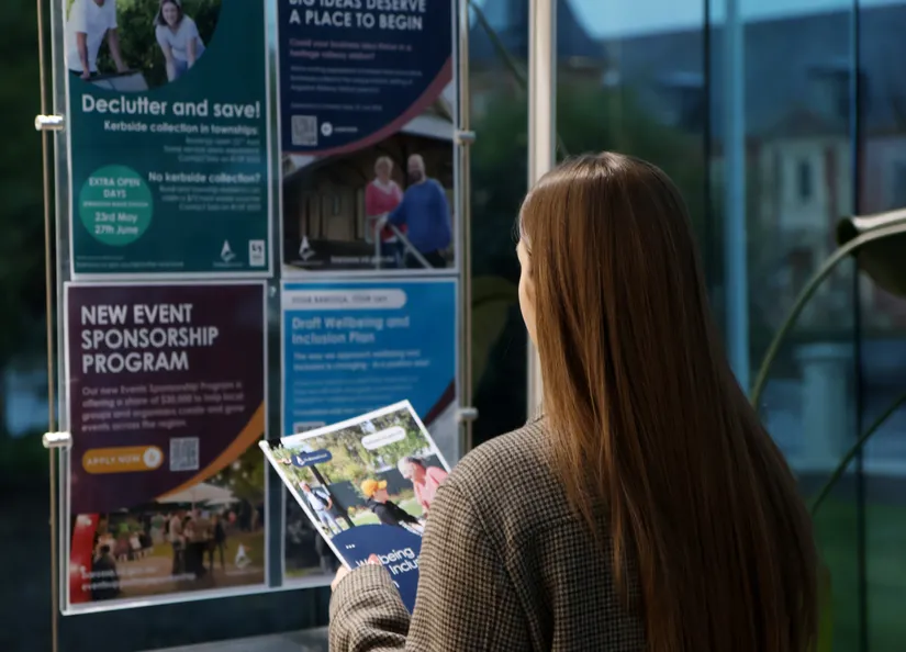 A person holding a book in front of posters