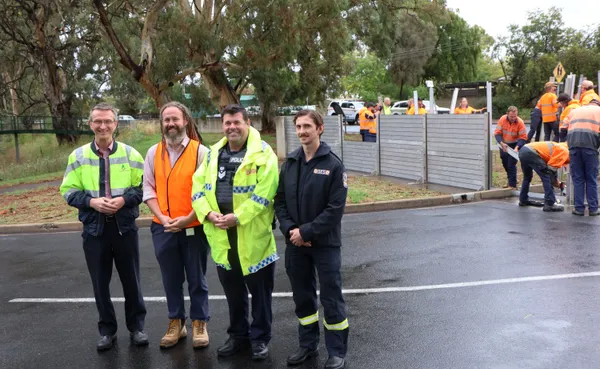 Flood wall drill showing SES and Police officer with Council staff installing wall in background