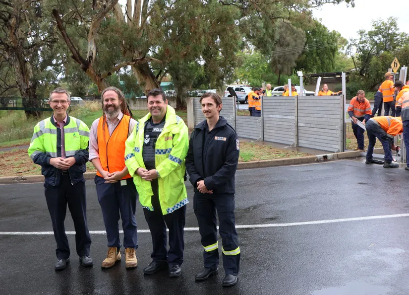 Flood wall drill showing SES and Police officer with Council staff installing wall in background