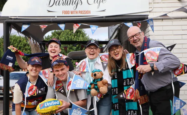 group of people with Gather Round bunting decorating the street