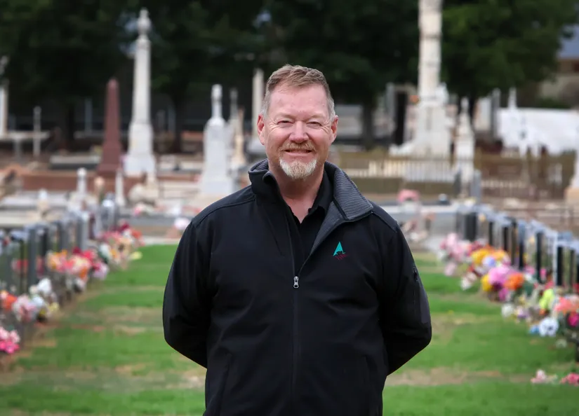 Jack Denherder standing on the lawns at Nuriootpa Cemetery with historic headstones in the background