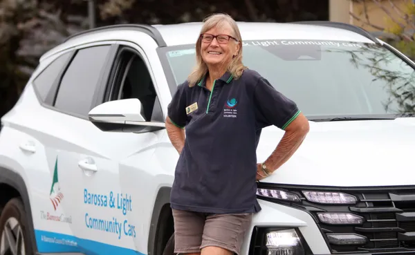 volunteer driver standing with community car