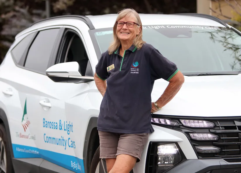volunteer driver standing with community car