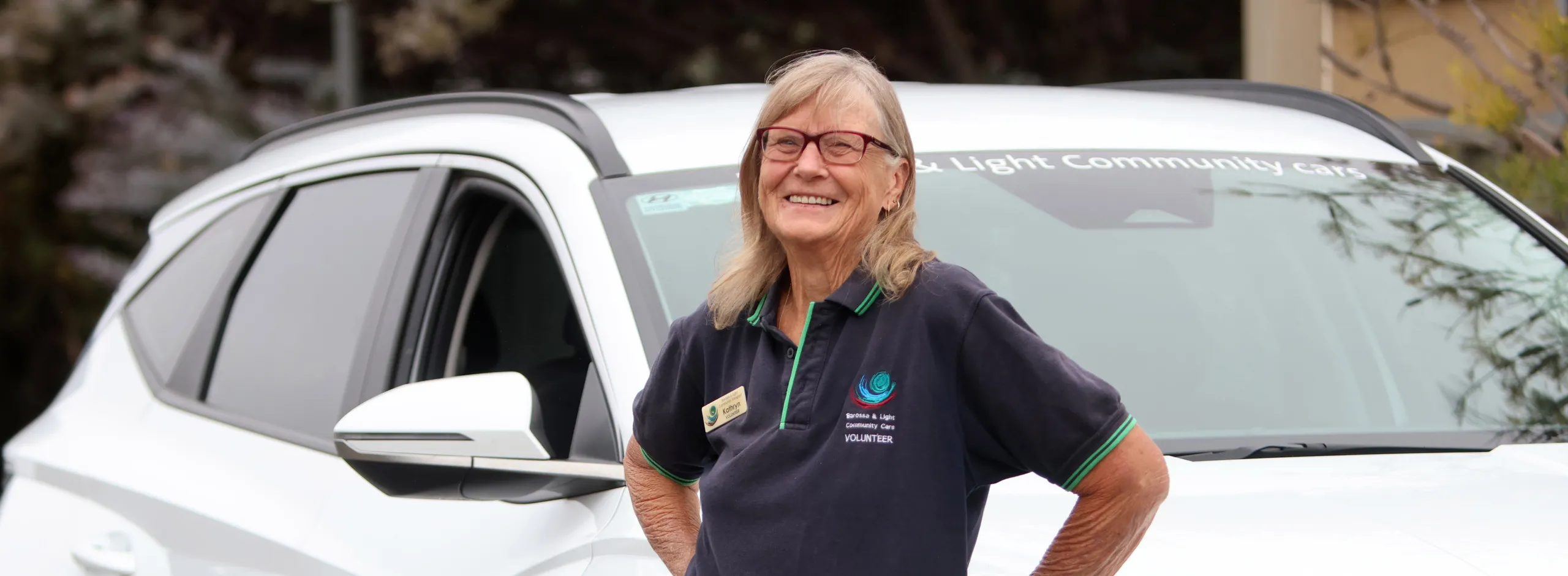 volunteer driver standing with community car