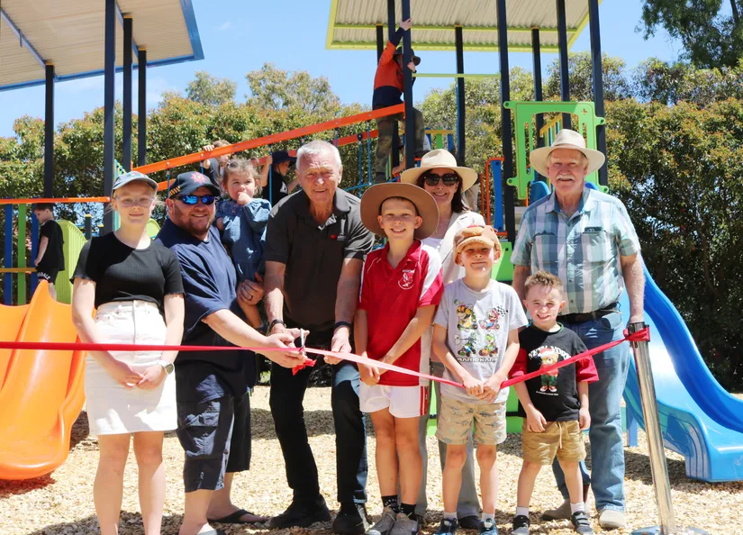 Children and representatives from The Barossa Council cutting a red ribbon to officially open the new playground Springton.