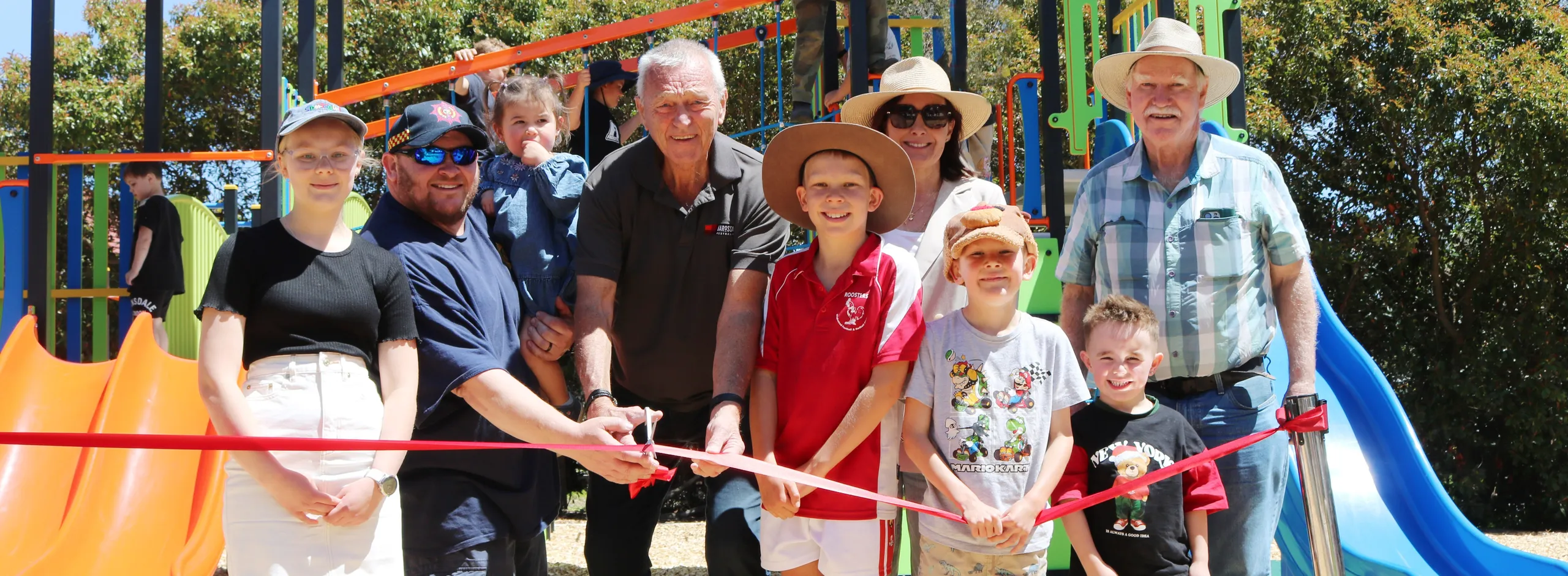 Children and representatives from The Barossa Council cutting a red ribbon to officially open the new playground Springton.