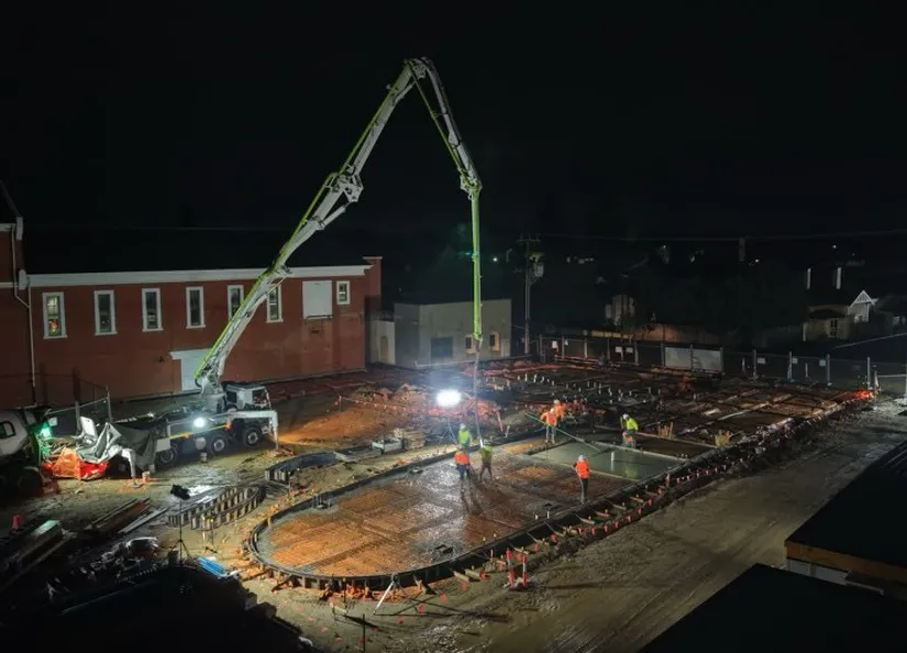 Dark image with large machinery hovering over mesh foundation