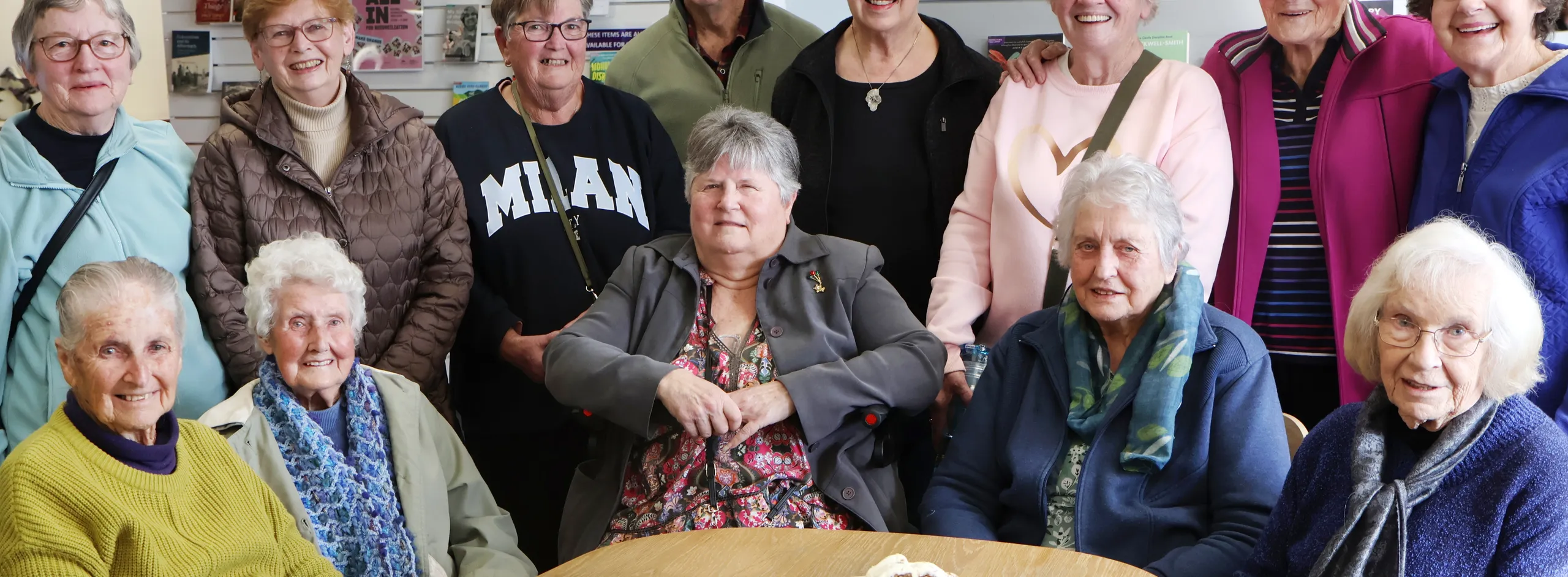 big group around a table chatting over afternoon tea