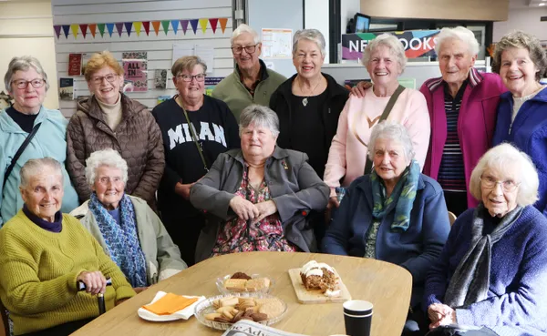 big group around a table chatting over afternoon tea