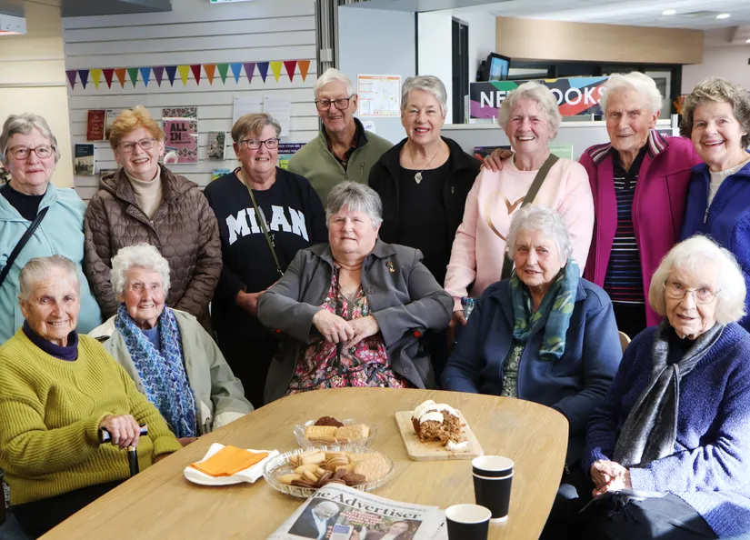 big group around a table chatting over afternoon tea